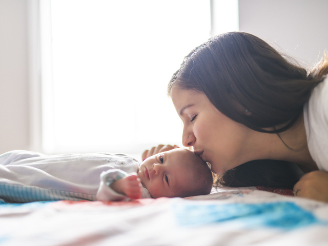 Mother kissing head of premature baby.jpg