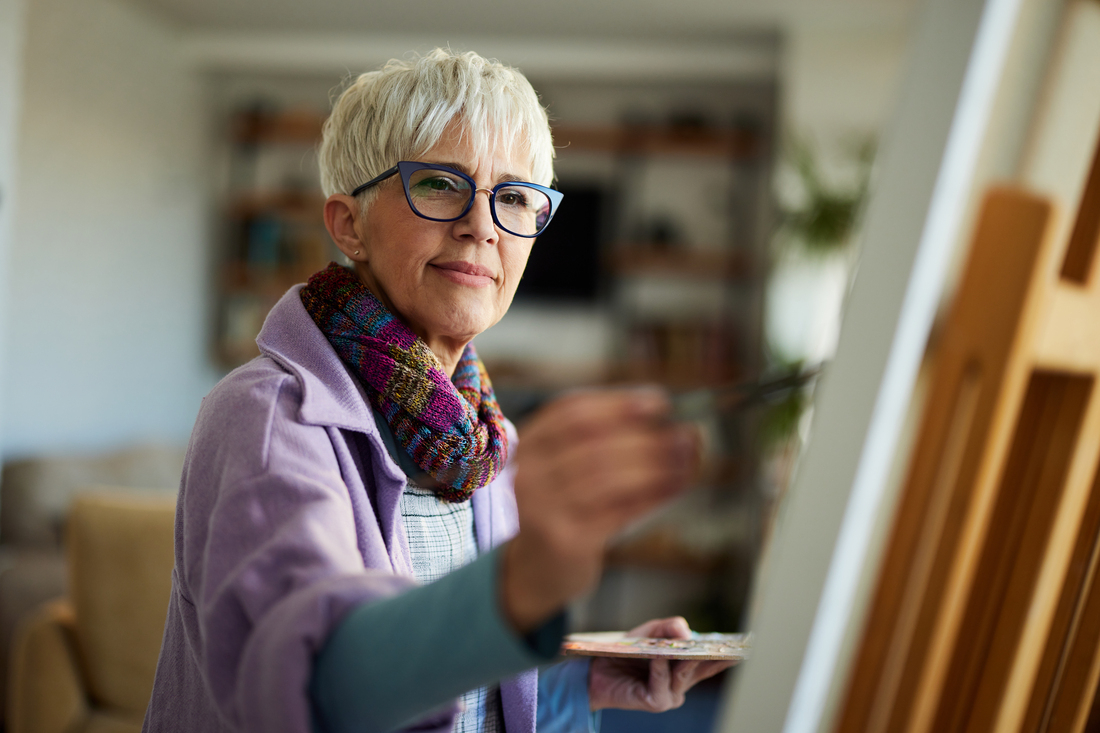 Smiling senior woman painting