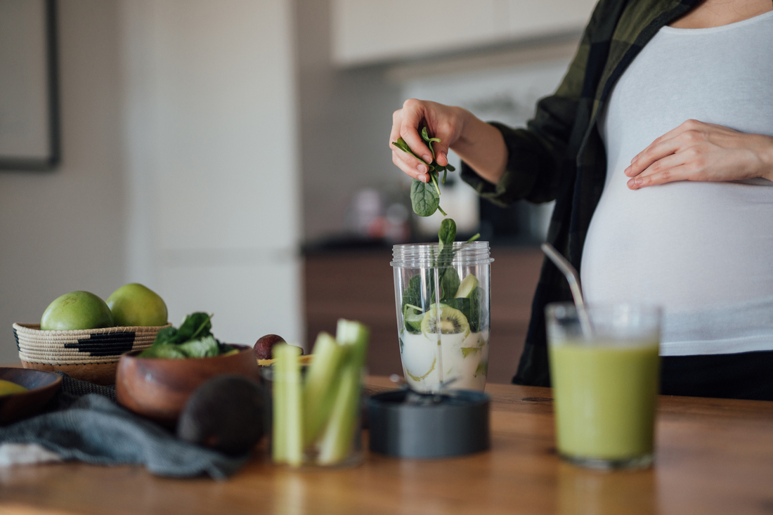 Pregnant woman making smoothie with folate