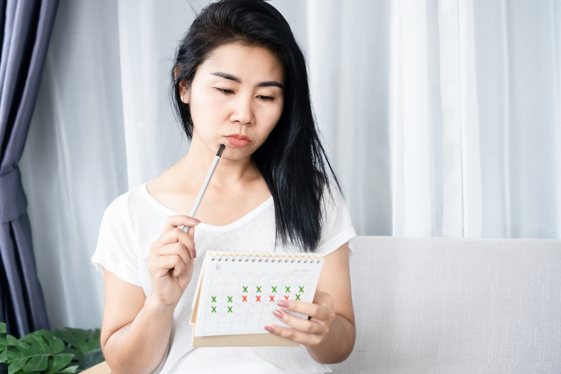 Woman looking at menstrual period calendar.jpg