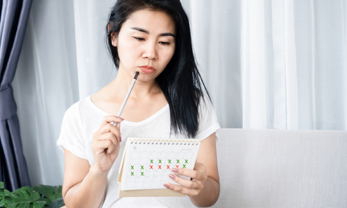 Woman looking at menstrual period calendar.jpg