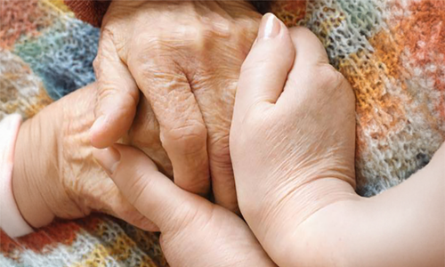 Two sets of hands holding one another