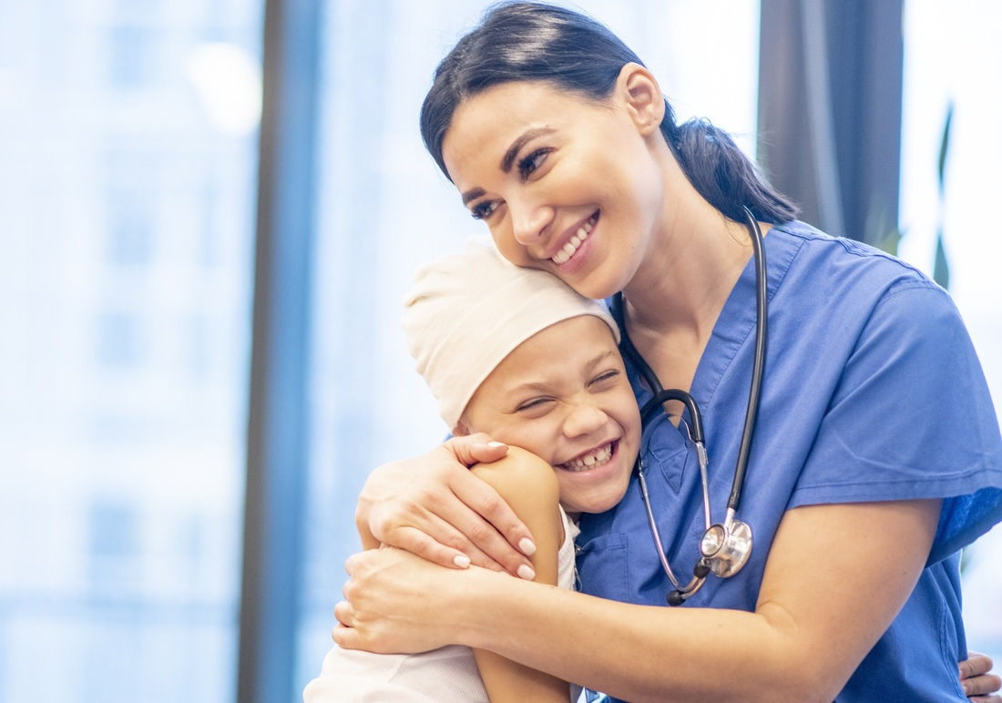 Happy nurse hugging pediatric patient.jpg