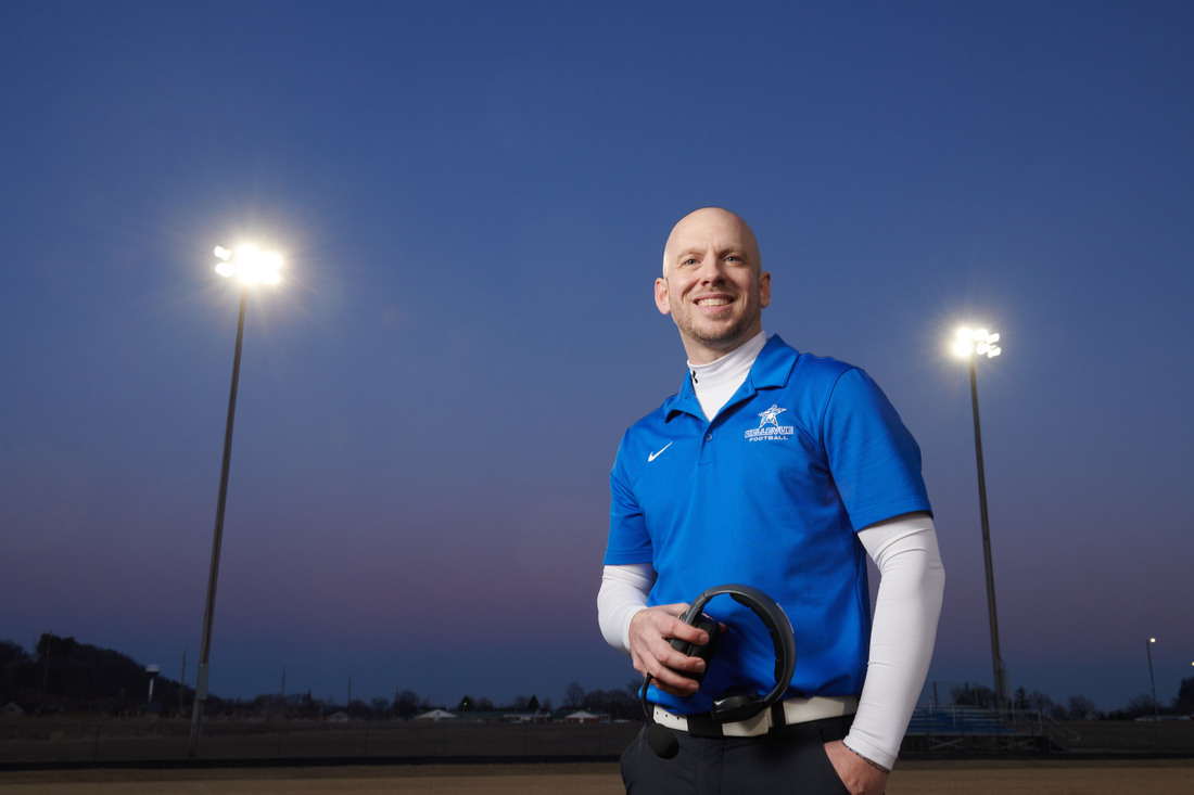 Jarred Koos smiling at camera with headphones in hand.JPG