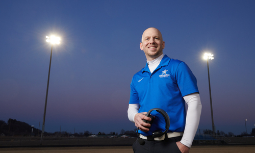 Jarred Koos smiling at camera with headphones in hand.JPG