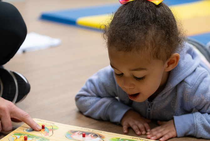 Girl laying on the ground looking at puzzle.jpg