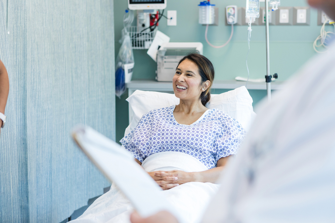 Female patient smiles in hospital bed.jpg