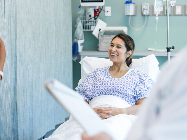 Female patient smiles in hospital bed.jpg