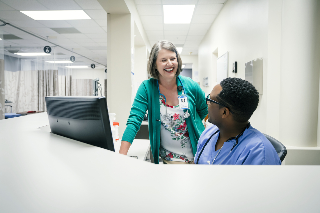 Doctor and nurse laughing by computer in ER.jpg