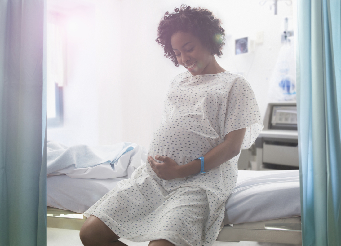 Pregnant woman smiling in hospital gown.jpg