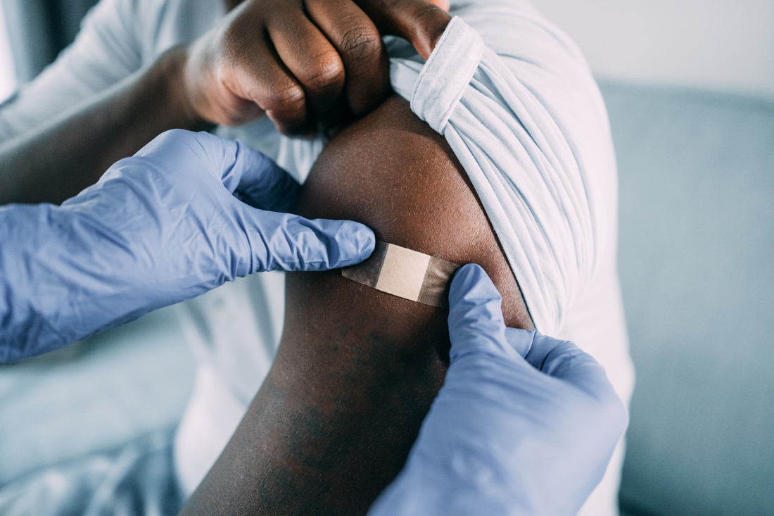 Provider putting bandaid on arm after vaccine.jpg