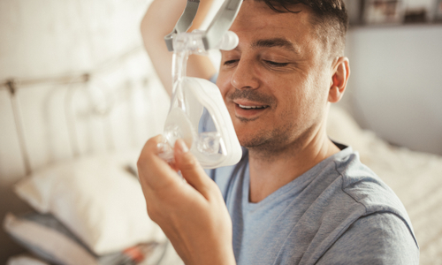 Man putting on CPAP mask.jpg