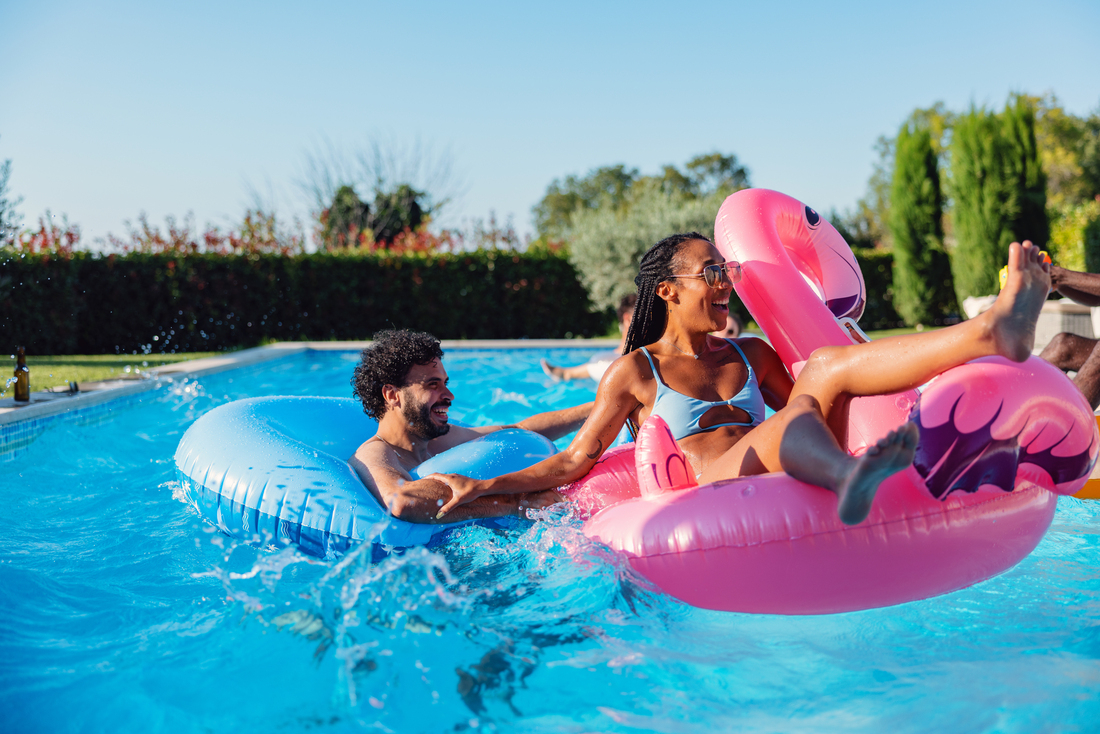 Smiling people using pool floaties in an outdoor pool.jpg
