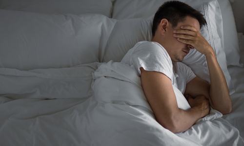 Person in bed with pillow over their head.jpg